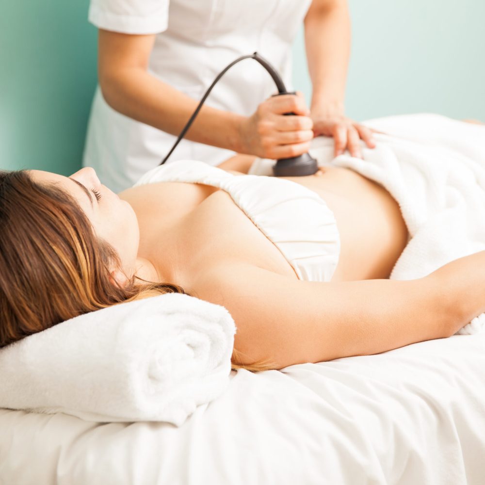 Femme thérapeute donnant un traitement réducteur et réaffirmant à une cliente et se concentrant sur son ventre